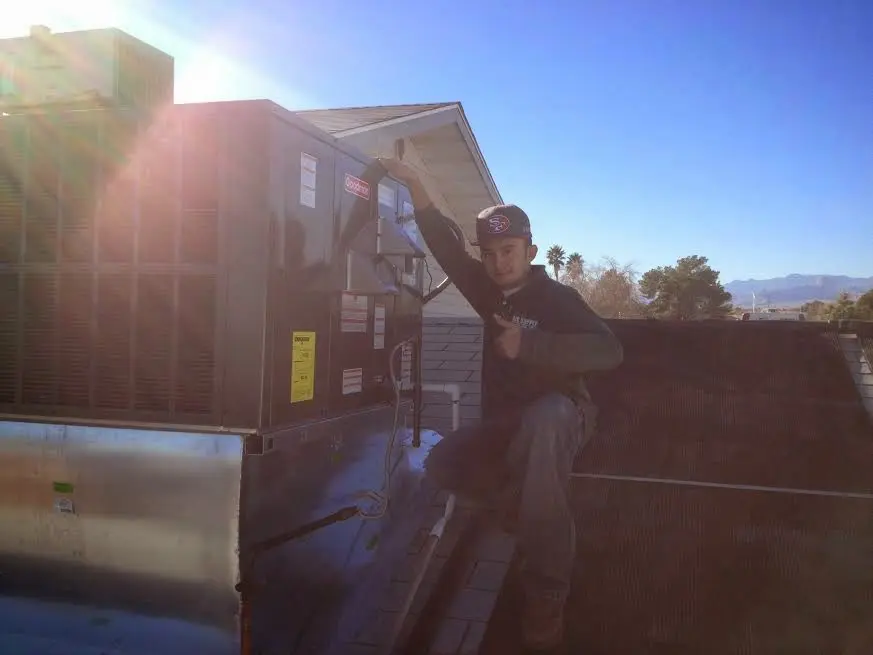HVAC technician performing AC Tune-Up on a rooftop unit in New Hempstead